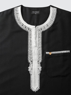 Top view of Imaarah Andalus Moroccan thobe neckline in black with white Moroccan embroidery and concealed front placket