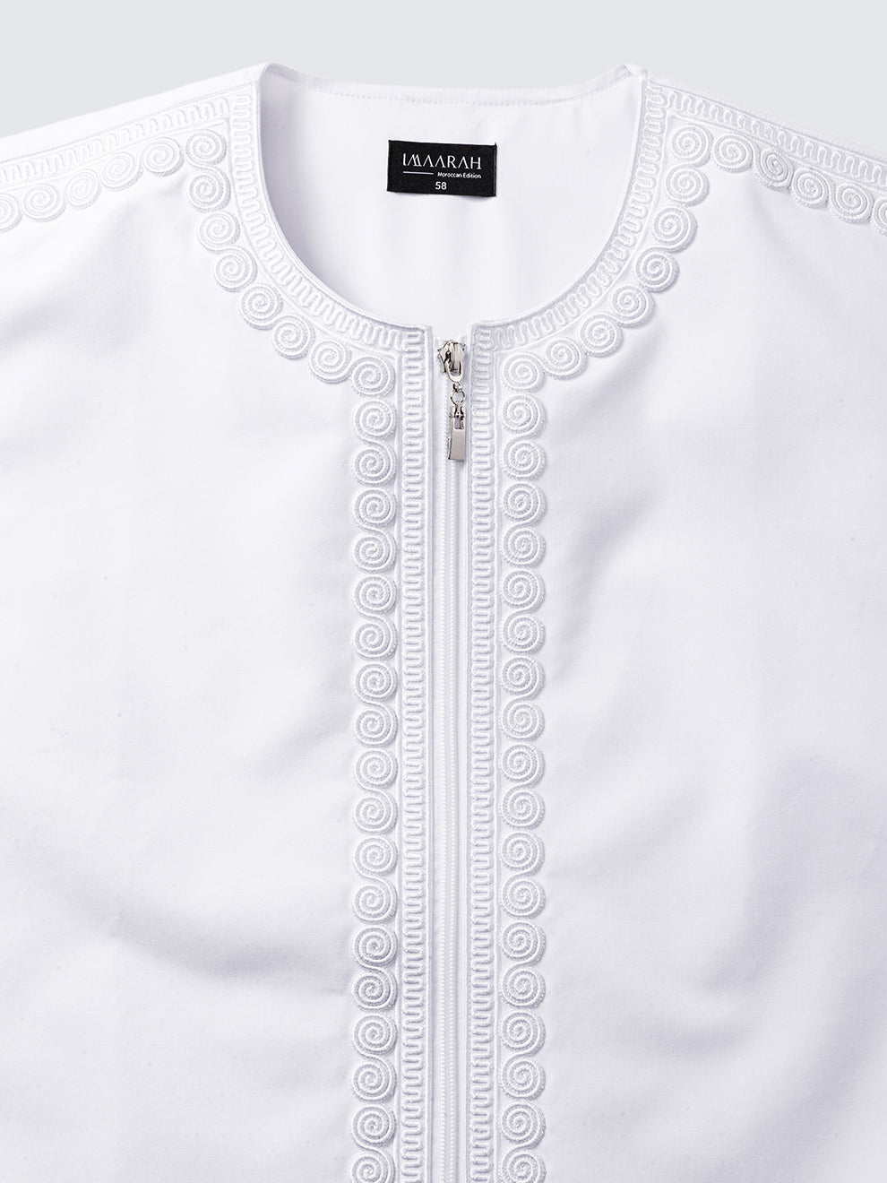 Close up of intricate imperial Moroccan embroidery on white thobe, showcasing fine craftsmanship and traditional hand finished detailing