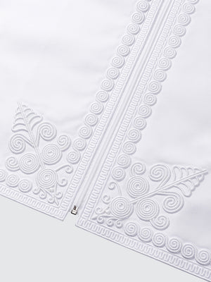 Close up of imperial Moroccan waistcoat embroidery in white, showcasing intricate patterns and high end traditional craftsmanship