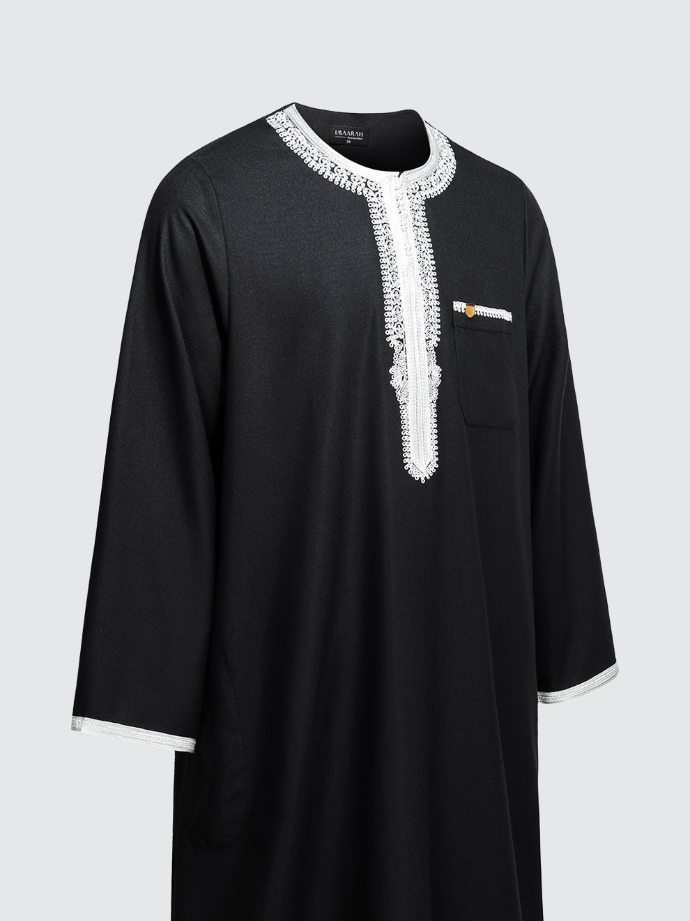 Imaarah Andalus long sleeve Moroccan thobe in black with white embroidery shown at an angled side view highlighting contrast detailing and relaxed fit