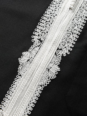 Close-up of white Moroccan embroidery on Imaarah Andalus long sleeve thobe showing detailed stitching and fabric texture on black base