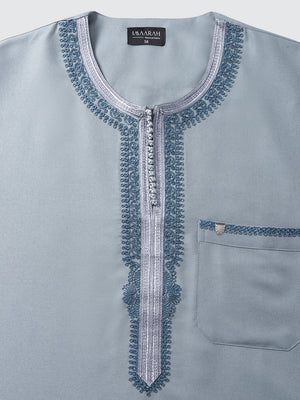 Close up of Moroccan neckline with blue embroidery on slate blue long sleeve thobe by Imaarah